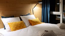 Hotelzimmer mit bunten Kissen auf dem Bett